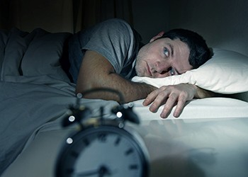 A man lying awake at night as a result of his insomnia