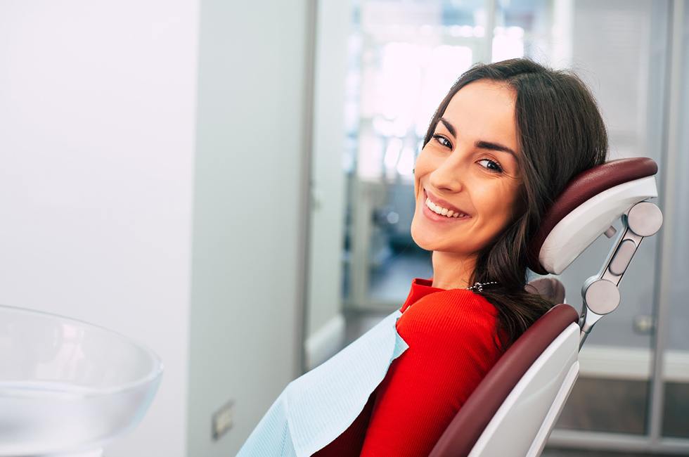 A young woman seated in the dentist’s chair and waiting to see her dentist in Midland for treatment