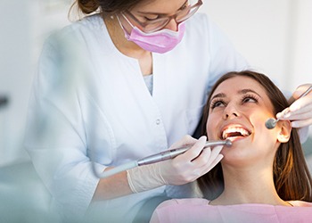 A dentist preparing to check a patient’s smile to offer recommended treatment options for improvement