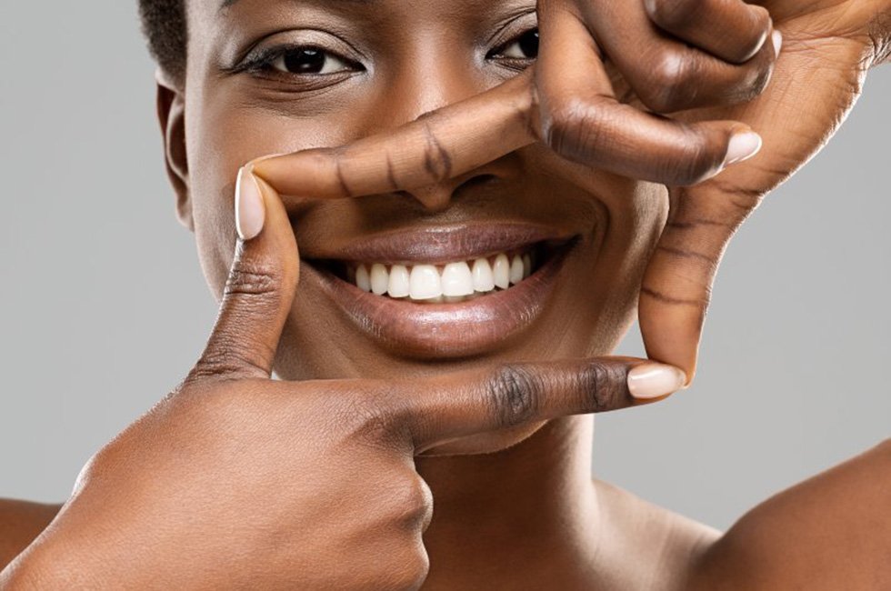 Woman creating a box around her smile with her fingers