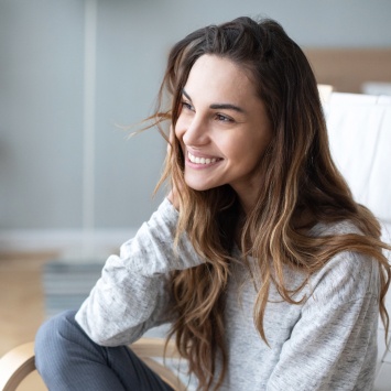 Smiling young woman wearing gray sweater