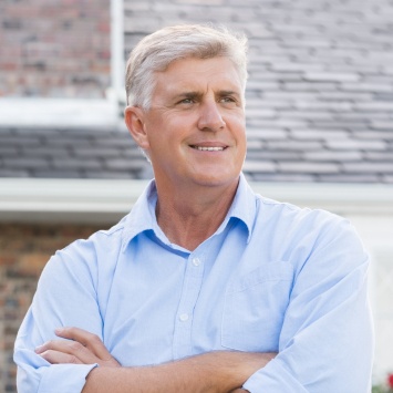 Older man standing in his front yard