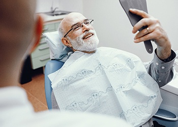 dental implant patient looking at his reflection 