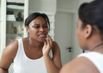 Woman grimacing due to effects of bruxism