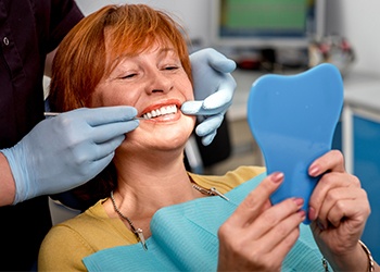 Woman looking at smile in mirror