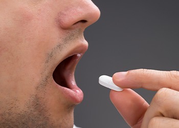 Closeup of patient taking oral sedative pill