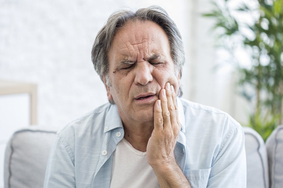 Man in pain holding jaw