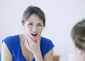 Woman in pain holding jaw