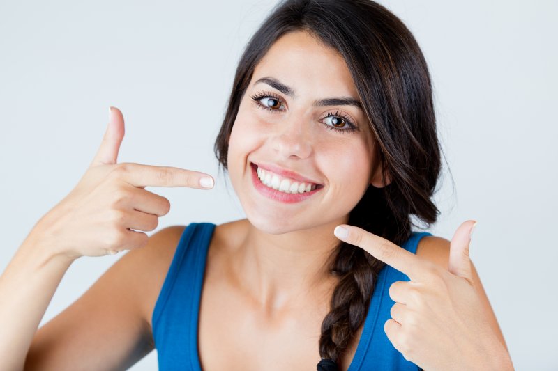 Woman pointing to her white teeth