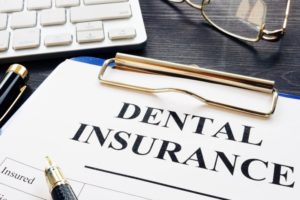 Dental insurance paperwork on clipboard from Midland dentist