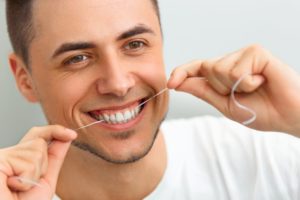 man flossing his teeth