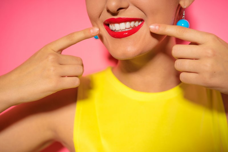 woman pointing at her smile in Midland 