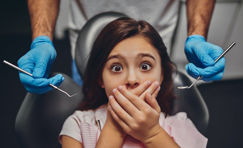 girl covering her mouth at dental visit in Midland