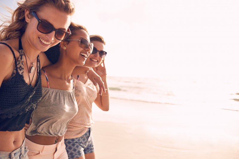 friends smiling during summer vacation at the beach