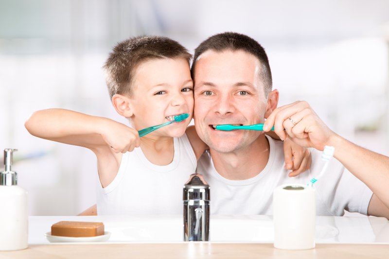 father and son brushing their teeth