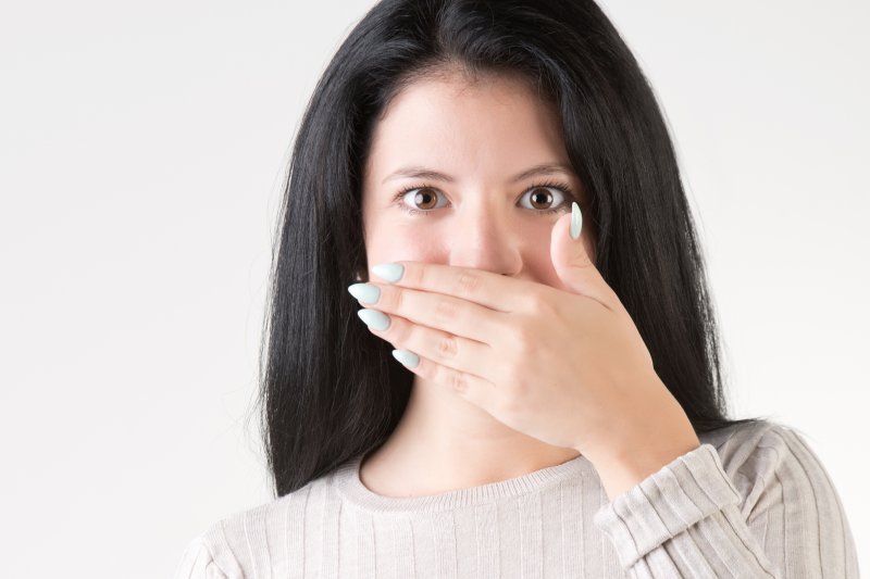 woman covering her smile