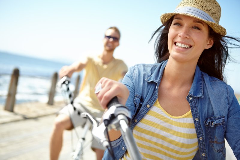A smiling woman cycling on her bike during summer vacation