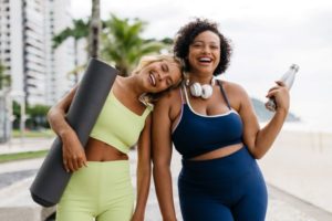 Two smiling women wearing workout clothing