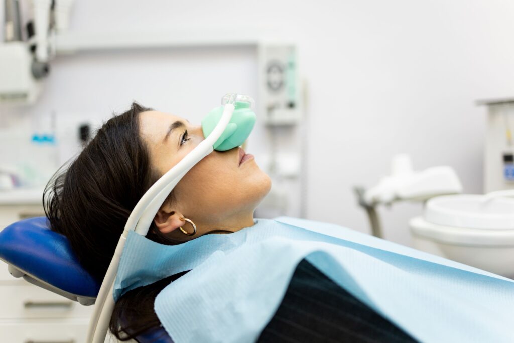 Profile view of woman in dental chair with nitrous oxide mask on