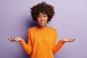 Woman shrugging her shoulders on purple background