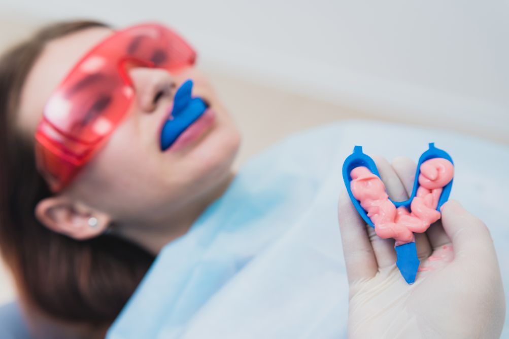 A woman getting fluoride treatment from a dentist