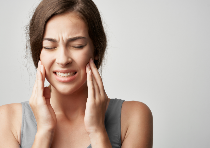 Woman wincing and holding cheeks